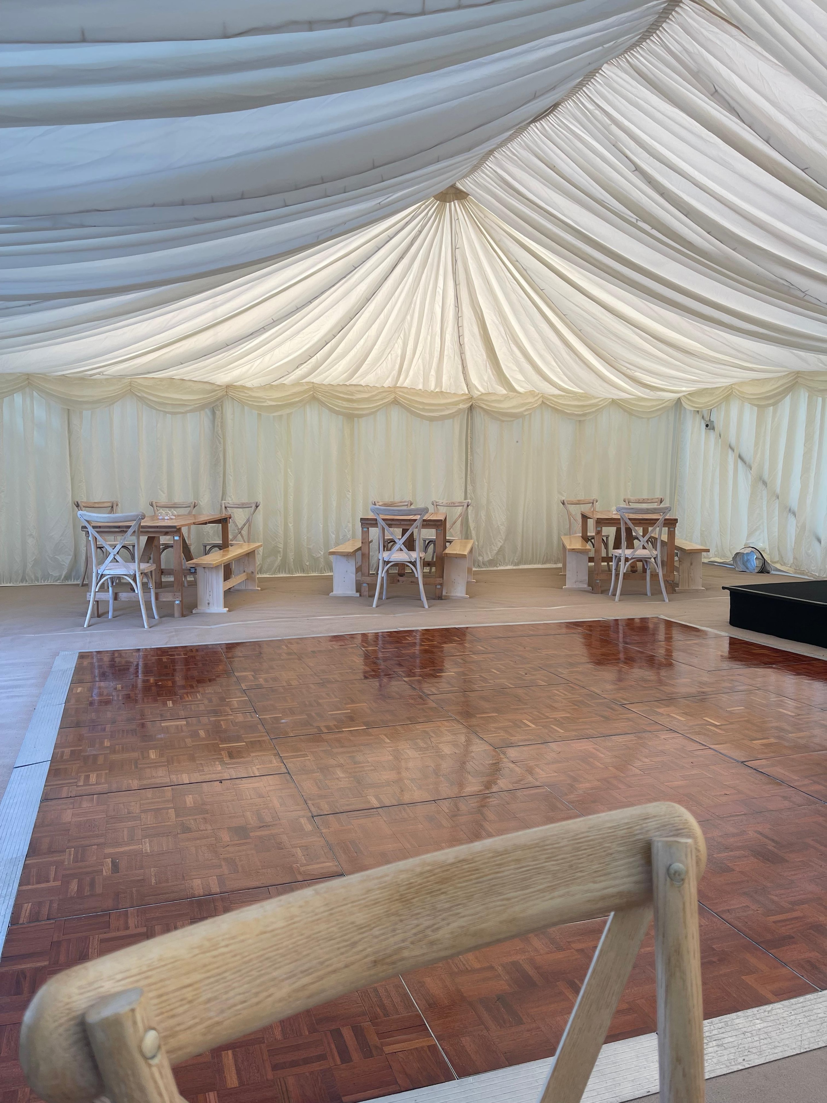 Elegant marquee interior with wooden chairs and parquet floor