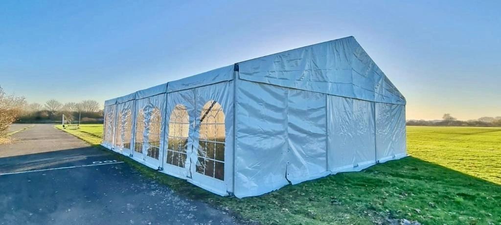 Marquee interior with banquet tables and floral arrangements