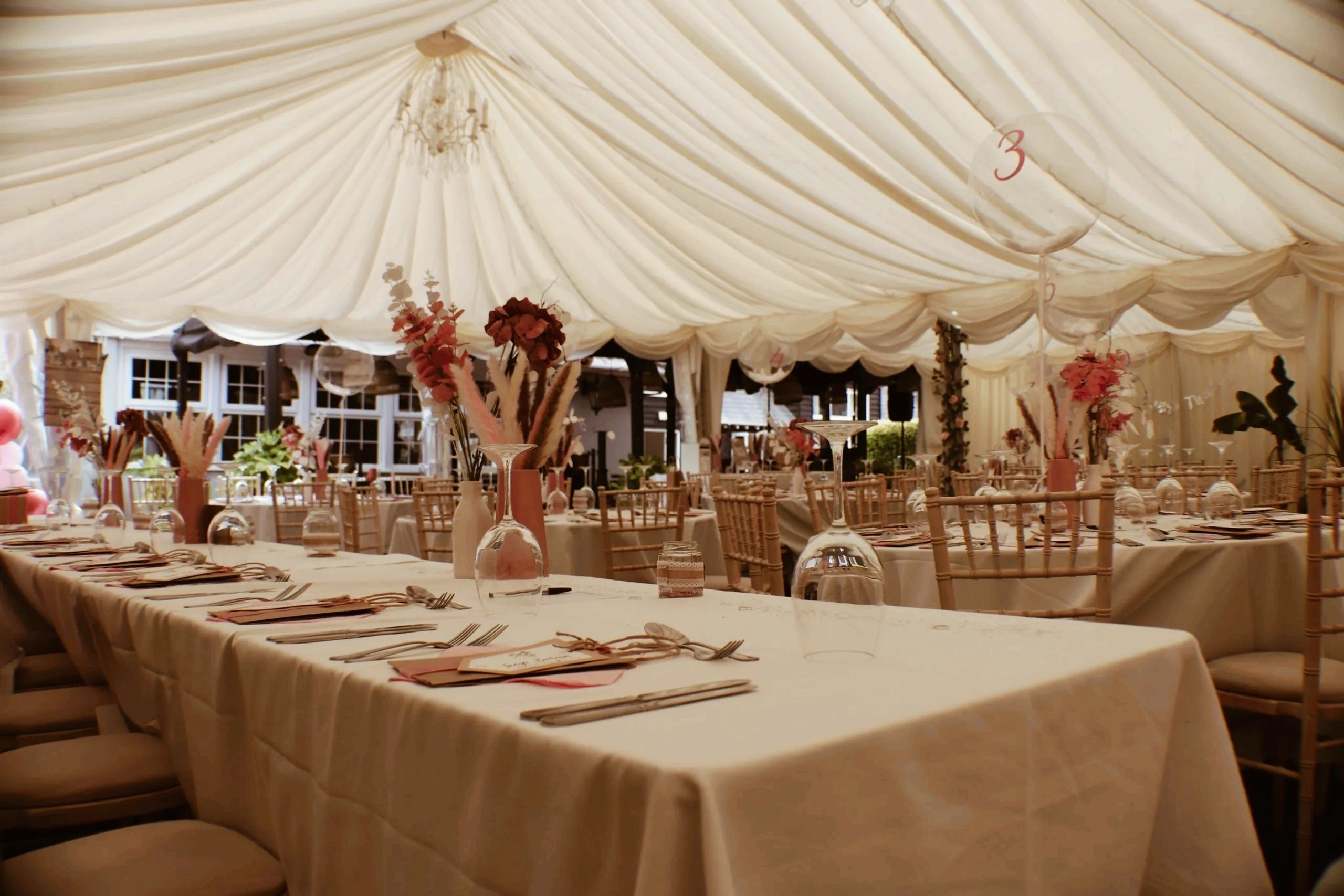 Elegant banquet table with cream linens, floral centrepieces and chandelier